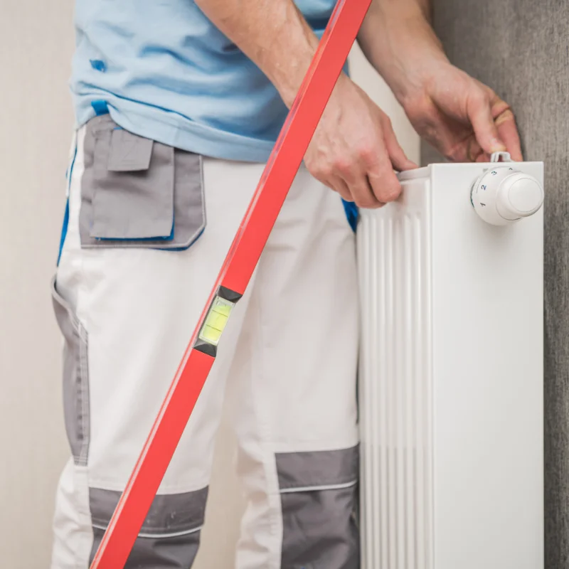 Handwerker schließt Heizkörper an