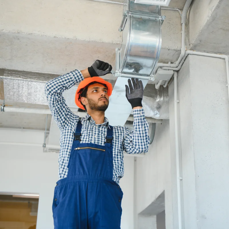 Handwerker arbeitet an Lüftungsanlage